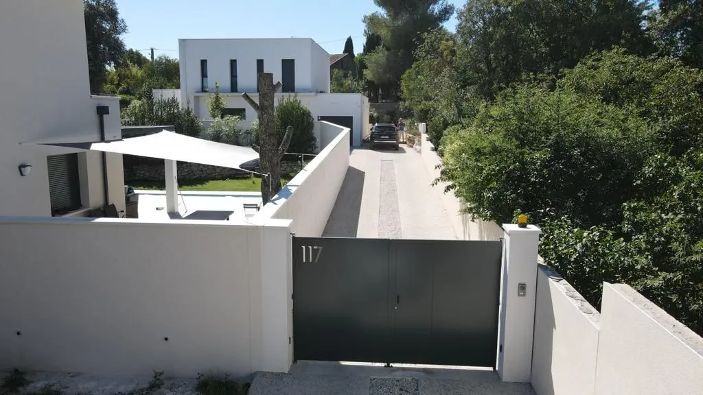 L’accès depuis la voie : portail, mur de clôture et rampe d’entrée